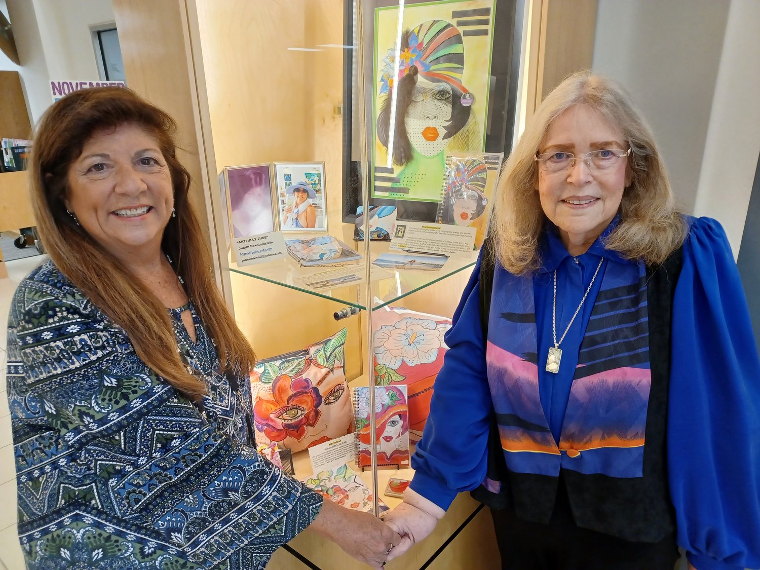 Loretta Leto, left, stands next to works of art by Judith Fox-Goldstein, right. The art is part of a PAM Jam showcase on display at the Ponte Vedra Library.